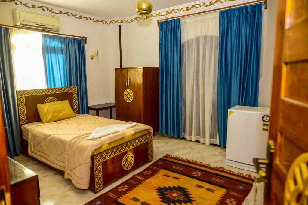 Cozy single room with comfortable bed and traditional wooden wardrobe in Luxor