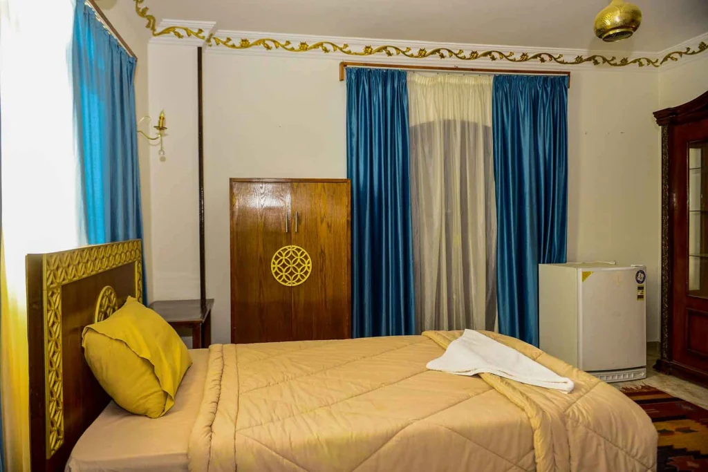 Cozy single room with comfortable bed and traditional wooden wardrobe in Luxor
