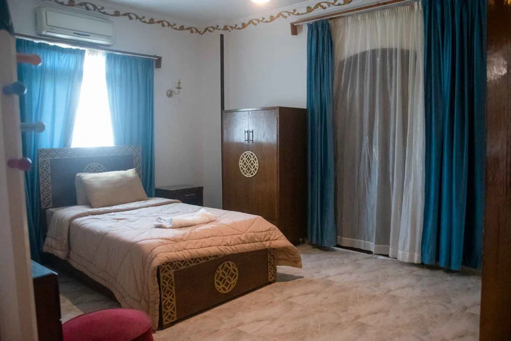 Cozy single room with comfortable bed and traditional wooden wardrobe in Luxor