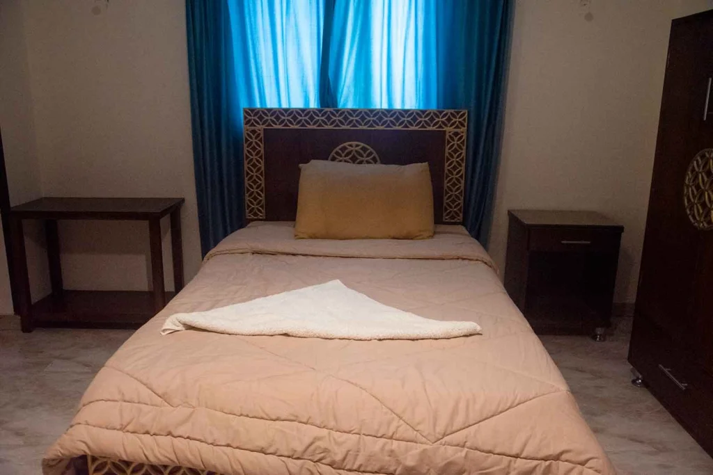 Cozy single room with comfortable bed and traditional wooden wardrobe in Luxor