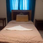 Cozy single room with comfortable bed and traditional wooden wardrobe in Luxor